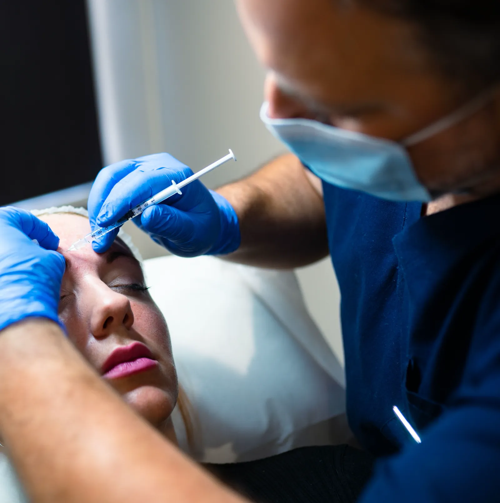 Doctor performing an aesthetic injection in a clinical setting